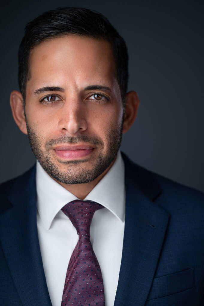 Nicholas Mukhtar, business strategy consultant, in a navy suit and maroon tie